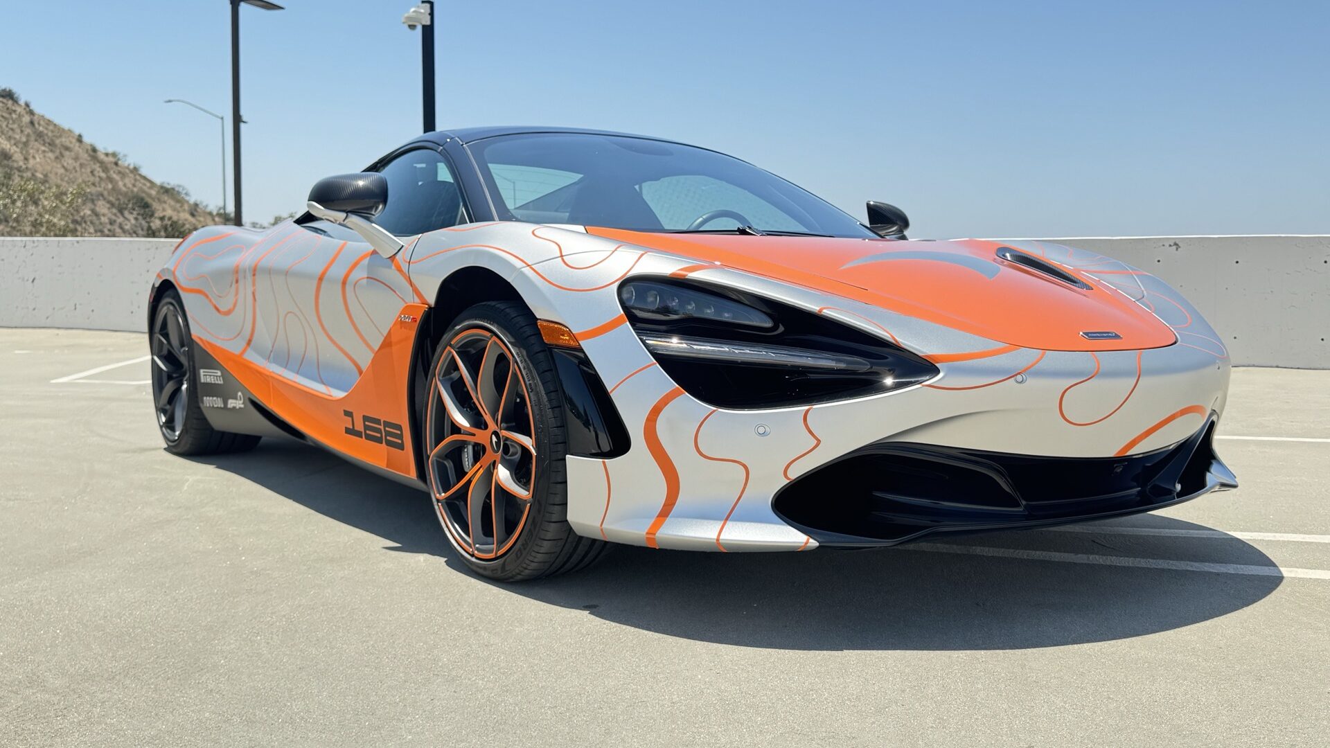 Voertuigwrap-ontwerp in de praktijk: rechtsvoor aanzicht van de McLaren 720S matte PPF wrap met oranje contourafbeeldingen door 2wrap.com